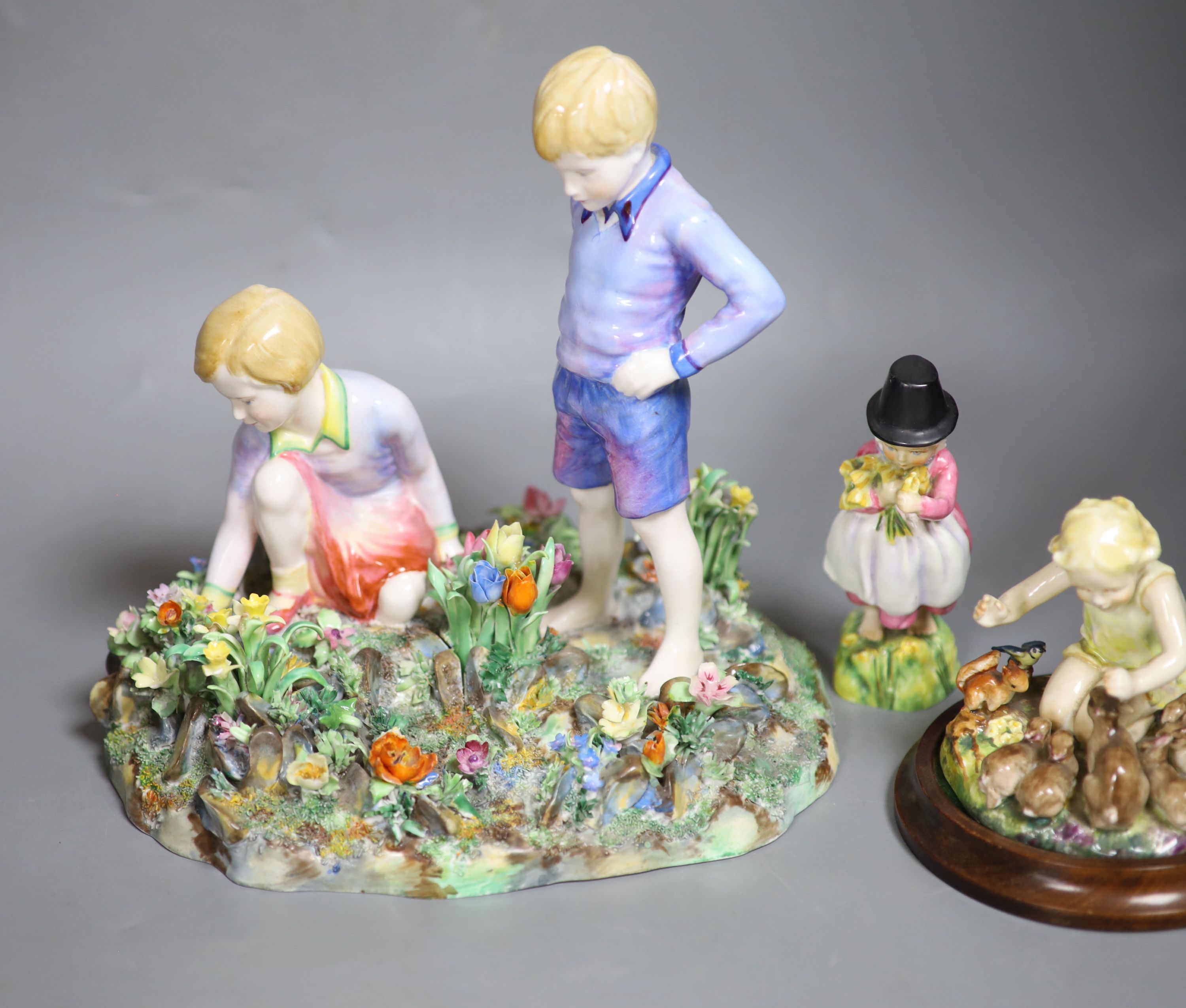 Four Royal Worcester figures of children by E.G. Doughty: 3150, 3076, 3103, 1416, and a larger Staffordshire table centre of a boy and